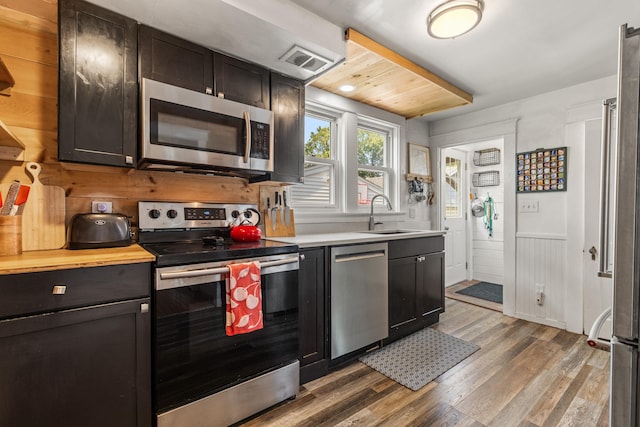 71 Hill St, Dover, NH 03820 - kitchen with appliances with stainless steel finishes, light wood-style floors, and wainscoting