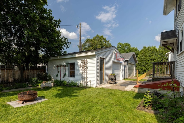 71 Hill St, Dover, NH 03820 - view of side of home with an outdoor fire pit, a detached garage, and an outbuilding