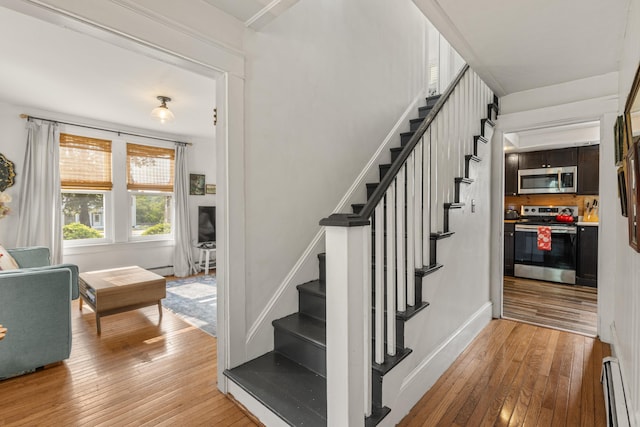 71 Hill St, Dover, NH 03820 - stairway with a baseboard heating unit and wood-type flooring