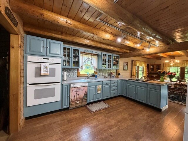 25 Rogers Way, Canaan, NH 03741 - kitchen featuring dishwashing machine, white double oven, a peninsula, a wooden ceiling with exposed beams, and a chandelier