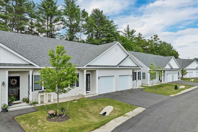 8C Villa Ln, Goffstown, NH 03045 - view of front of house featuring an attached garage, board and batten siding, a front yard, a shingled roof, and driveway