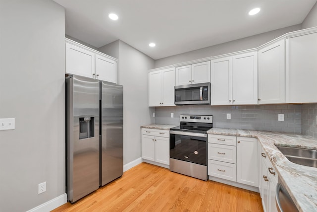 8C Villa Ln, Goffstown, NH 03045 - kitchen with appliances with stainless steel finishes, white cabinetry, tasteful backsplash, light wood-style floors, and recessed lighting