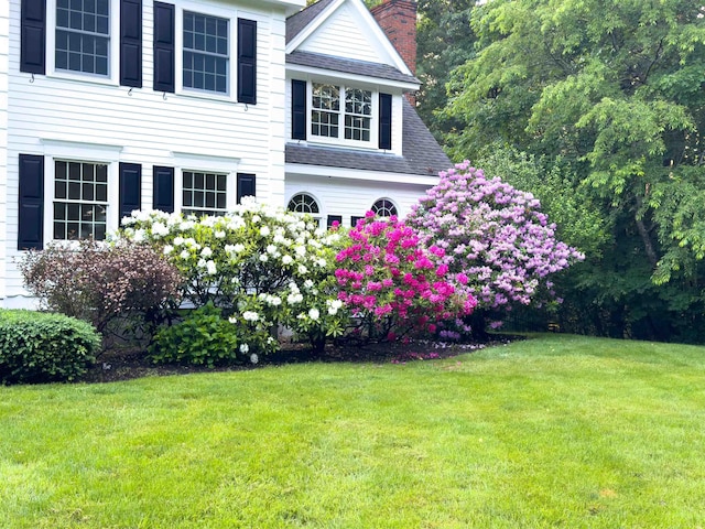 69 Exeter Rd, North Hampton, NH 03862 - view of home's exterior with roof with shingles, a yard, and a chimney