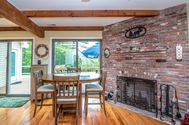 30 Thoreau Trl, Wakefield, NH 03830 - dining area featuring hardwood / wood-style floors, beam ceiling, and a brick fireplace
