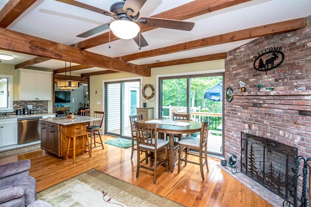 30 Thoreau Trl, Wakefield, NH 03830 - dining space featuring light wood-style flooring, beamed ceiling, a ceiling fan, and a fireplace