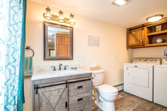 30 Thoreau Trl, Wakefield, NH 03830 - full bathroom with washing machine and dryer, wood finished floors, vanity, and a baseboard heating unit