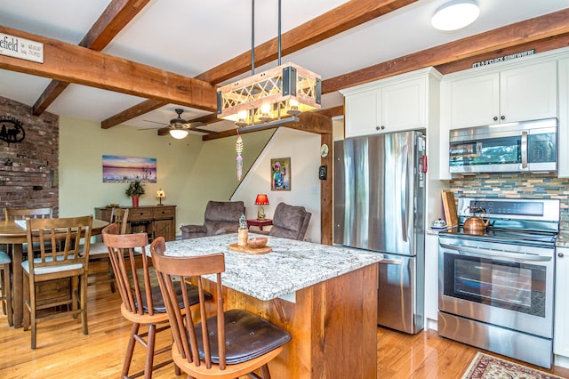 30 Thoreau Trl, Wakefield, NH 03830 - kitchen featuring stainless steel appliances, light wood-style floors, beamed ceiling, ceiling fan, and white cabinets