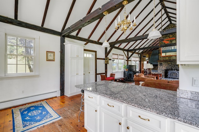 102 Hubbard Hill Rd, Rindge, NH 03461 - kitchen with baseboard heating, a chandelier, hardwood / wood-style floors, white cabinetry, and high vaulted ceiling