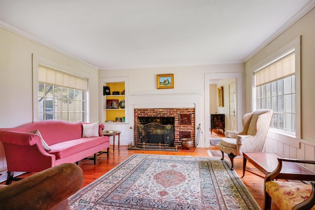 102 Hubbard Hill Rd, Rindge, NH 03461 - living room with wood finished floors, crown molding, a brick fireplace, and built in shelves