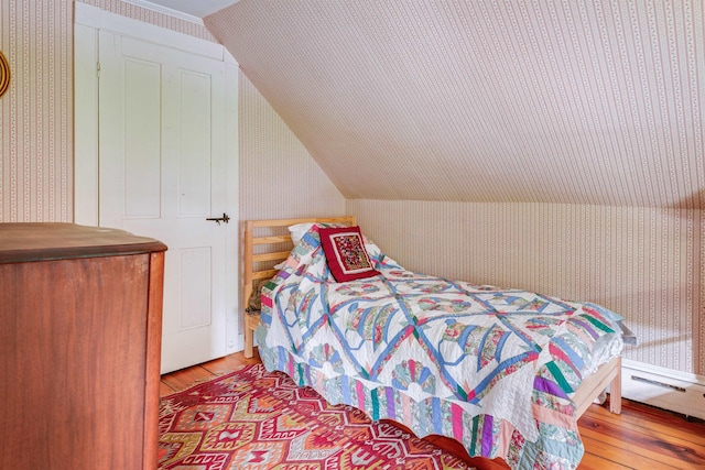102 Hubbard Hill Rd, Rindge, NH 03461 - bedroom featuring wallpapered walls, wood-type flooring, and vaulted ceiling