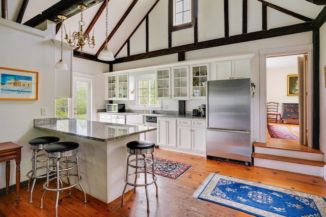 102 Hubbard Hill Rd, Rindge, NH 03461 - kitchen featuring stainless steel appliances, high vaulted ceiling, a kitchen breakfast bar, white cabinets, and light wood-style floors