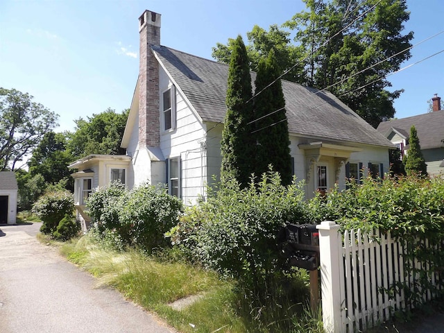 25 Downing St, Concord, NH 03301 - view of property exterior with a chimney and a shingled roof
