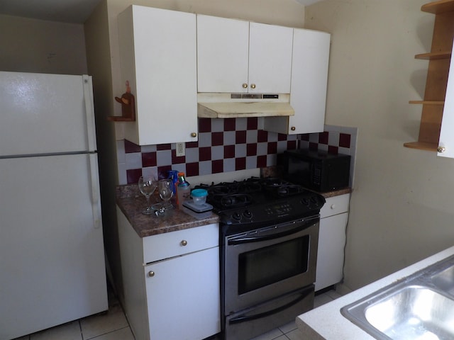 25 Downing St, Concord, NH 03301 - kitchen with freestanding refrigerator, under cabinet range hood, gas stove, black microwave, and decorative backsplash
