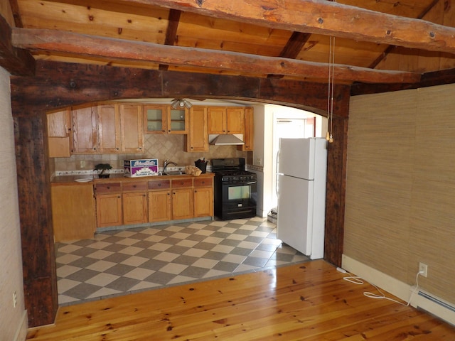 25 Downing St, Concord, NH 03301 - kitchen with black range with gas cooktop, freestanding refrigerator, under cabinet range hood, beamed ceiling, and a baseboard heating unit