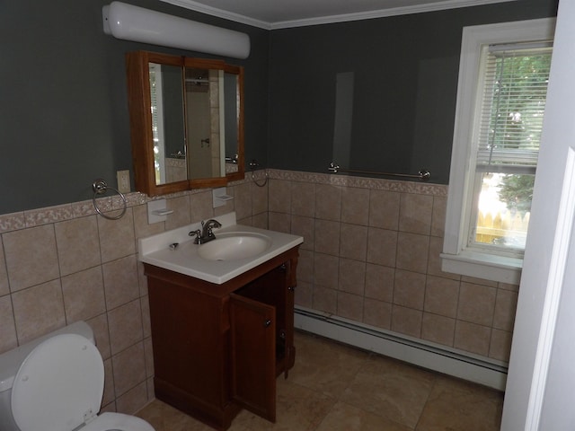 25 Downing St, Concord, NH 03301 - bathroom featuring a baseboard heating unit, tile walls, vanity, tile patterned flooring, and ornamental molding