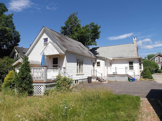 25 Downing St, Concord, NH 03301 - back of property featuring a deck, a chimney, and roof with shingles