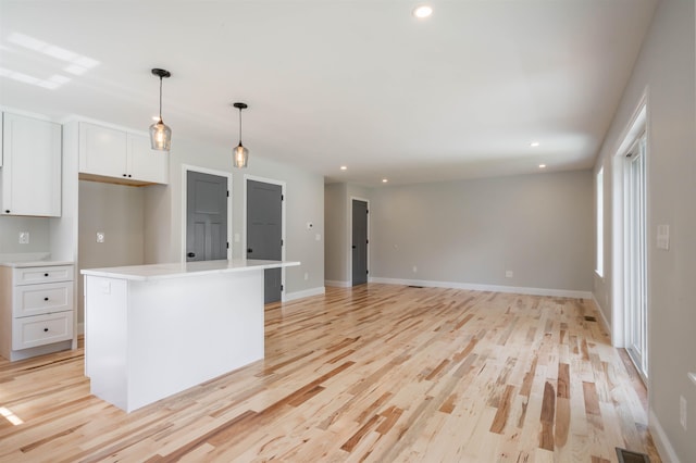 72-1 N Mast St, Goffstown, NH 03045 - kitchen with white cabinets, light wood-style floors, recessed lighting, light countertops, and hanging light fixtures