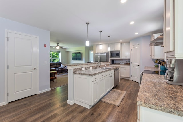 23 Pork Hill Rd, Ossipee, NH 03864 - kitchen with stainless steel appliances, wall chimney range hood, white cabinetry, dark wood-style floors, and open floor plan