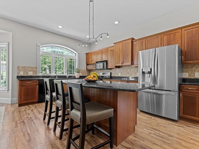 1 Dragonfly Way, Londonderry, NH 03053 - kitchen with black appliances, backsplash, a kitchen bar, healthy amount of natural light, and recessed lighting