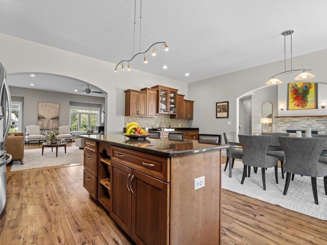 1 Dragonfly Way, Londonderry, NH 03053 - kitchen with arched walkways, open floor plan, light wood finished floors, backsplash, and recessed lighting
