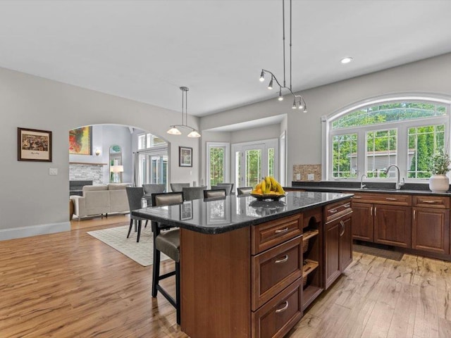 1 Dragonfly Way, Londonderry, NH 03053 - kitchen featuring a kitchen breakfast bar, arched walkways, light wood-style flooring, a center island, and open floor plan