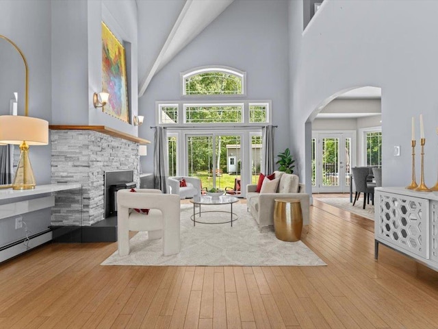 1 Dragonfly Way, Londonderry, NH 03053 - living area with arched walkways, high vaulted ceiling, wood-type flooring, and baseboard heating