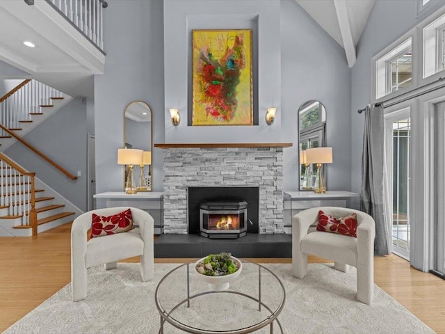 1 Dragonfly Way, Londonderry, NH 03053 - living area featuring high vaulted ceiling, wood finished floors, stairs, and a stone fireplace