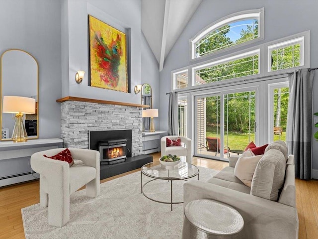 1 Dragonfly Way, Londonderry, NH 03053 - living room with high vaulted ceiling, a baseboard radiator, wood finished floors, and a stone fireplace