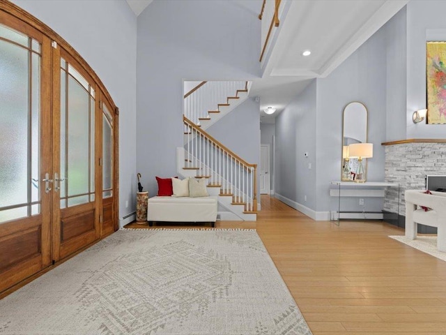 1 Dragonfly Way, Londonderry, NH 03053 - entryway featuring french doors, a towering ceiling, wood finished floors, stairs, and a baseboard heating unit