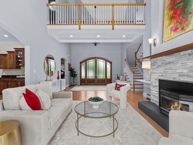 1 Dragonfly Way, Londonderry, NH 03053 - living area featuring a towering ceiling, arched walkways, wood finished floors, stairway, and recessed lighting