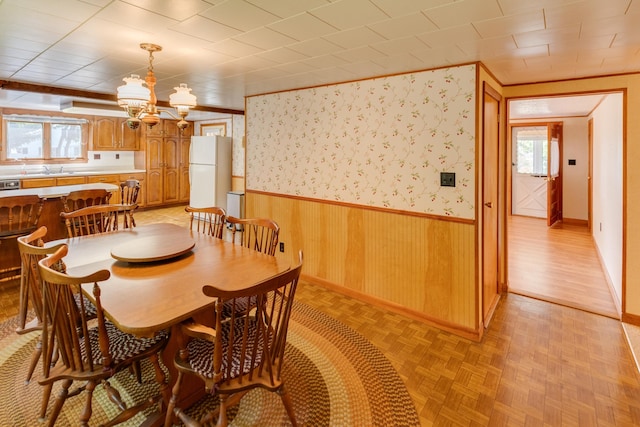 141 Manns Hill Rd, Littleton, NH 03561 - dining room featuring a wainscoted wall, a chandelier, wood walls, and parquet flooring