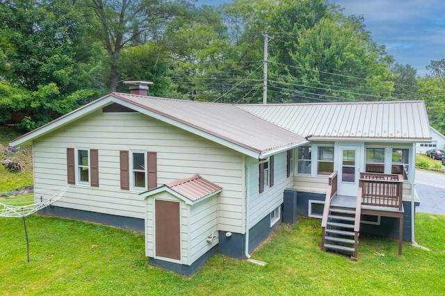 141 Manns Hill Rd, Littleton, NH 03561 - back of property with a metal roof, a lawn, stairway, and a deck