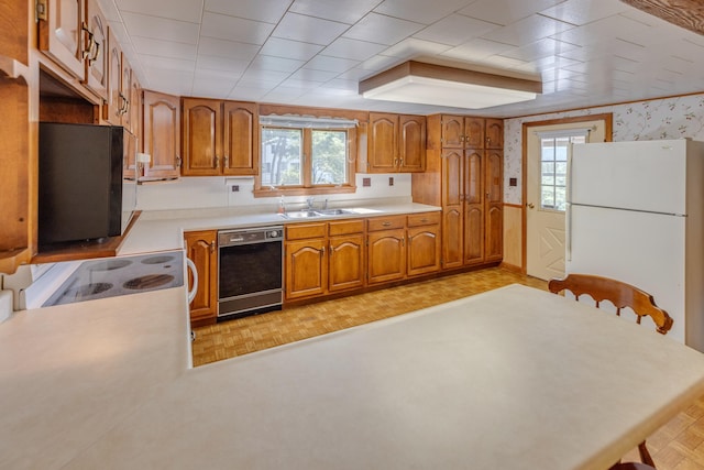 141 Manns Hill Rd, Littleton, NH 03561 - kitchen featuring white appliances, brown cabinetry, light countertops, and wallpapered walls