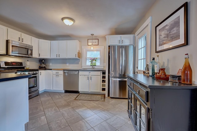 15 Arbor St # 1, Exeter, NH 03833 - kitchen with appliances with stainless steel finishes, dark countertops, white cabinetry, and pendant lighting