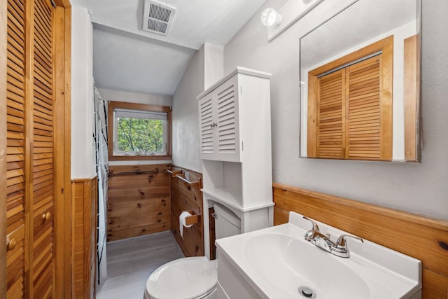 396 Mica Point Rd, Barrington, NH 03825 - bathroom with vanity, vaulted ceiling, a closet, wainscoting, and wood finished floors