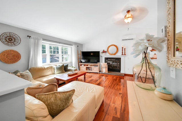 20 Cimmarron Dr, Nashua, NH 03062 - living room with a wall mounted AC, vaulted ceiling, wood finished floors, and a glass covered fireplace