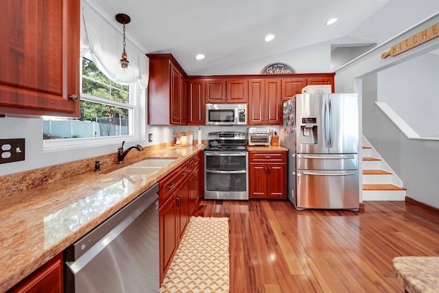 20 Cimmarron Dr, Nashua, NH 03062 - kitchen with stainless steel appliances, pendant lighting, light stone countertops, vaulted ceiling, and wood finished floors