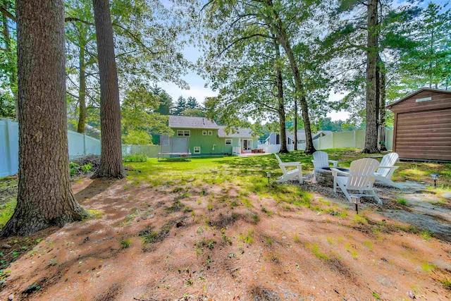 20 Cimmarron Dr, Nashua, NH 03062 - fenced backyard featuring a fire pit and a storage unit