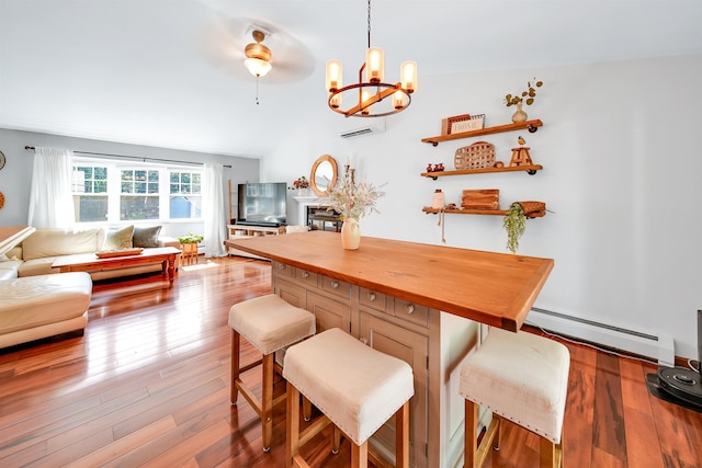 20 Cimmarron Dr, Nashua, NH 03062 - dining room with a baseboard heating unit, a wall unit AC, wood finished floors, and a chandelier