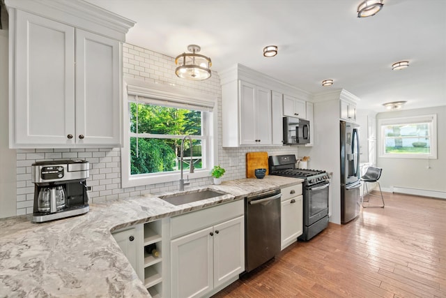 38 Heald St, Goffstown, NH 03102 - kitchen with stainless steel appliances, tasteful backsplash, white cabinetry, a baseboard radiator, and light stone counters