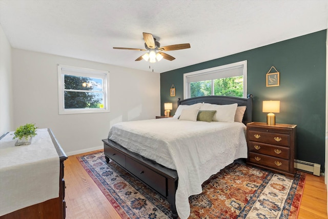 38 Heald St, Goffstown, NH 03102 - bedroom with baseboard heating, wood finished floors, and a ceiling fan