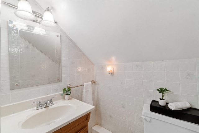 38 Heald St, Goffstown, NH 03102 - bathroom with tile walls, vaulted ceiling, vanity, and tasteful backsplash