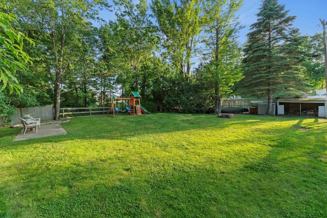 38 Heald St, Goffstown, NH 03102 - fenced backyard with a playground, a patio area, and view of wooded area