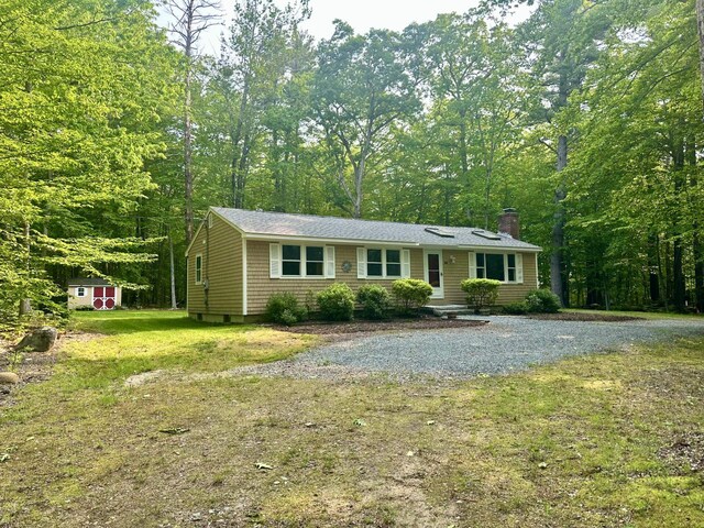 144 Windermere Rd, Moultonborough, NH 03254 - single story home with a chimney, a shed, a front lawn, and a forest view