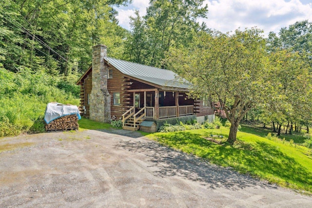 572 Old Cheshire Tpke, Charlestown, NH 03603 - log-style house featuring log siding, covered porch, a chimney, and a standing seam roof