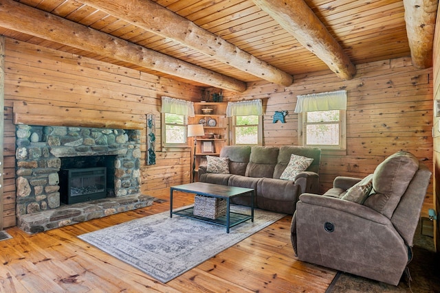 572 Old Cheshire Tpke, Charlestown, NH 03603 - living room featuring a wood ceiling with exposed beams, wooden walls, hardwood / wood-style floors, and a fireplace