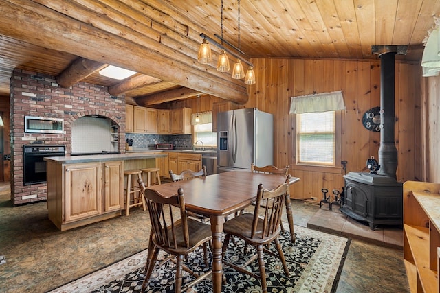 572 Old Cheshire Tpke, Charlestown, NH 03603 - dining area with a wood stove, wooden ceiling, and wood walls