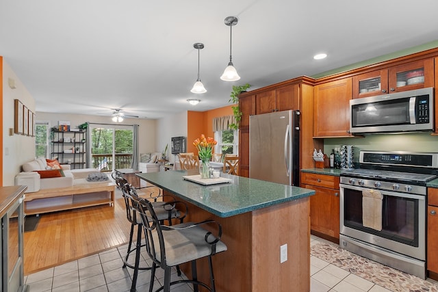 317 Old Concord Tpke Unit 1, Barrington, NH 03825 - kitchen with appliances with stainless steel finishes, light tile patterned floors, a breakfast bar, and open floor plan