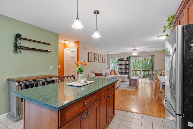 317 Old Concord Tpke Unit 1, Barrington, NH 03825 - kitchen featuring freestanding refrigerator, light tile patterned floors, a ceiling fan, and a center island