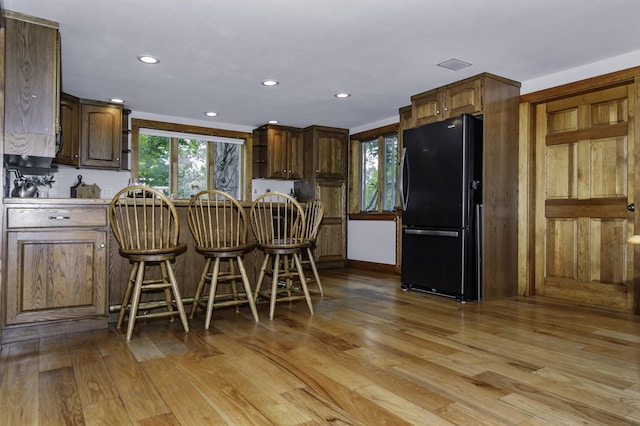 153 N Rd, Brentwood, NH 03833 - kitchen featuring freestanding refrigerator, light wood-style flooring, a breakfast bar area, recessed lighting, and a peninsula